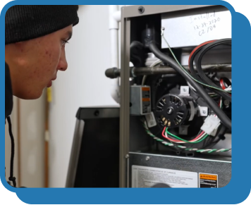 Someone looks at the interior of a furnace unit with cables and cords exposed