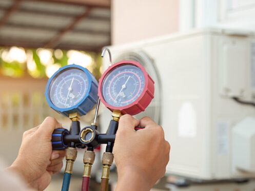 HVAC technician using gauge during maintenance